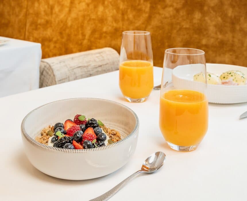 Frühstück am Tisch: Müsli, frisches Obst und frisch gepresste Säfte