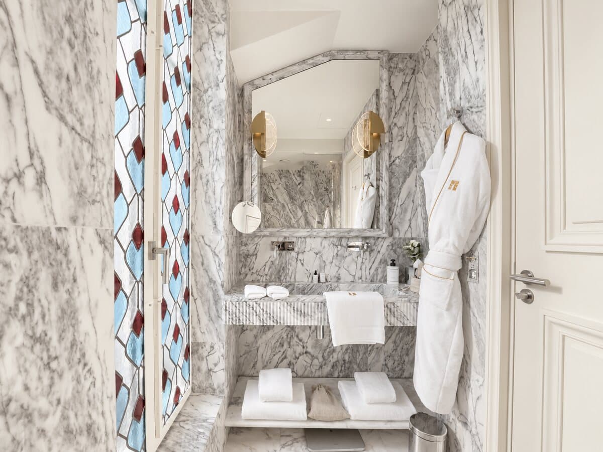 Marmorbad der Junior Suite Arc mit Glasfenster und Bademantel