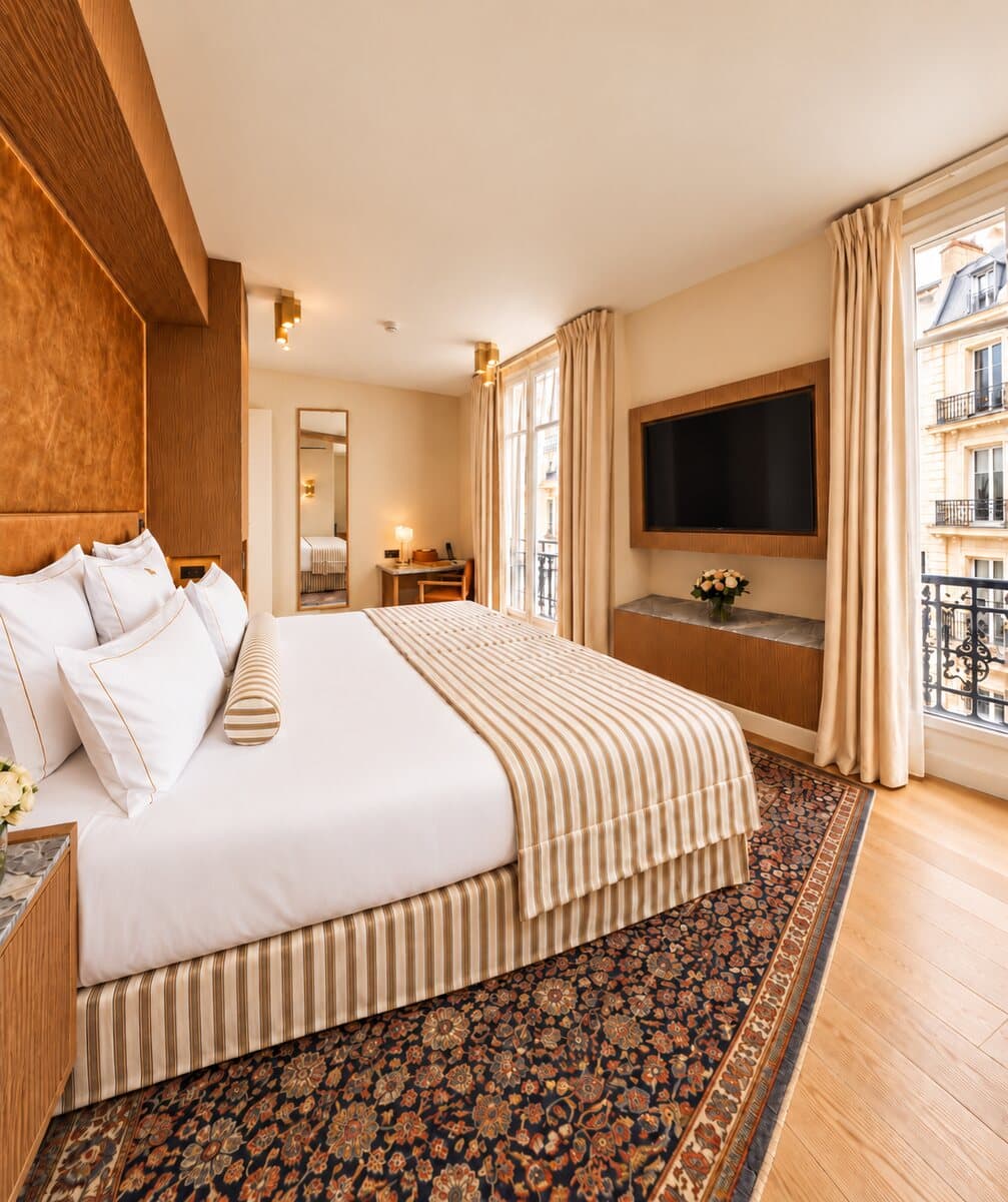 Junior Suite Étoile: Kingsize-Bett und Fenster zur Stadt