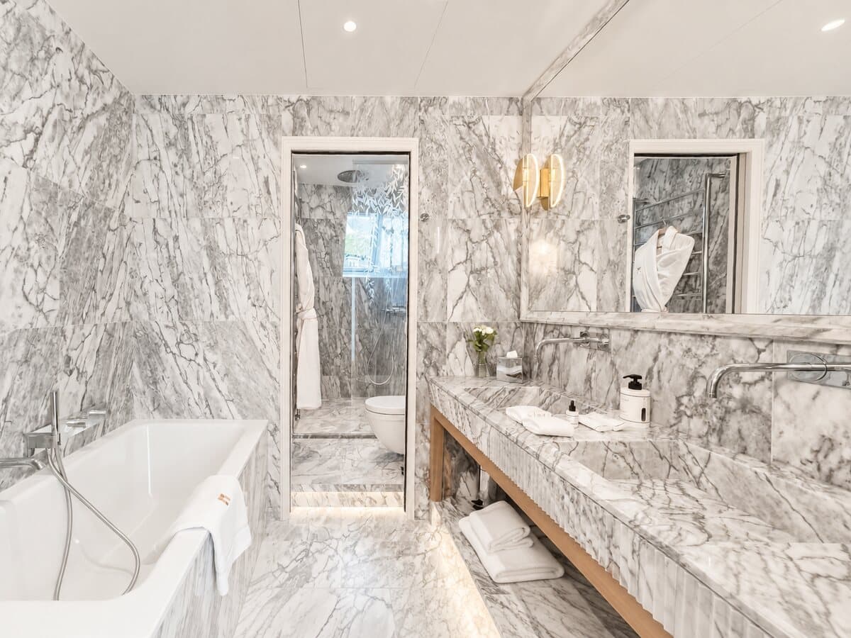Marmorbad der Junior Suite Étoile mit Badewanne und bodengleicher Dusche